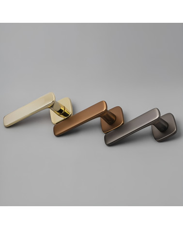 Poignée de porte FLOW poignée design présentée sur une surface grise
