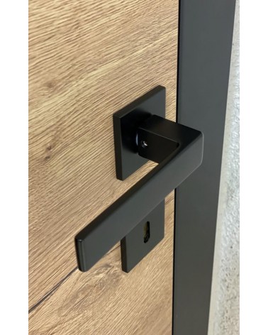 Poignée de porte noire Apollo poignée design vue de haut inclinée montée sur une porte
