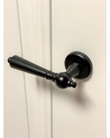 Poignée de porte noire MILLENAIRE poignée design vue de haut inclinée montée sur une porte