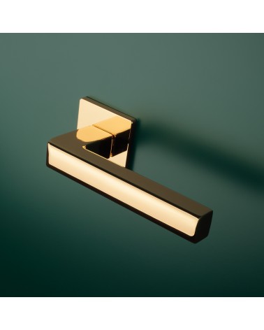 Poignée de porte or poli SALICE quincaillerie design montée sur une porte