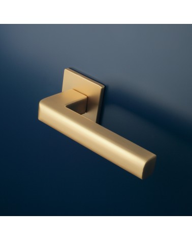 Poignée de porte or mate SALICE quincaillerie design montée sur une porte