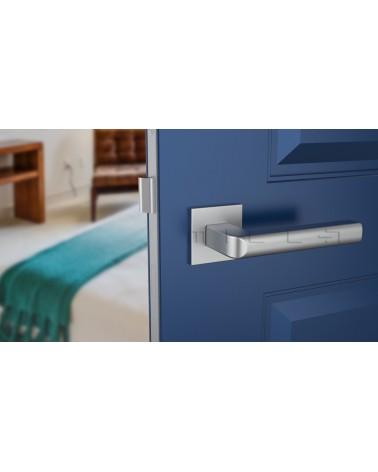 Poignée de porte chrome satiné SALICE quincaillerie design vue de face montée sur une porte