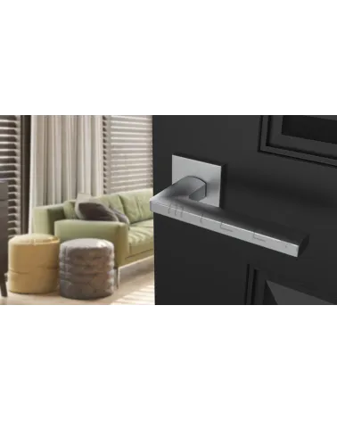Poignée de porte chrome satiné PYROLA quincaillerie design vue inclinée montée sur une porte