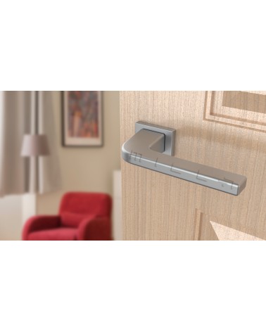 Poignée de porte chrome satiné ISMENA quincaillerie design vue inclinée montée sur une porte
