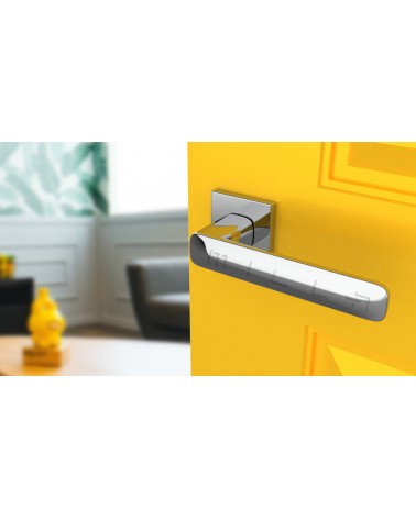 Poignée de porte sur plaque carrée STELLA quincaillerie design couleur 2 vue de haut inclinée montée sur une porte