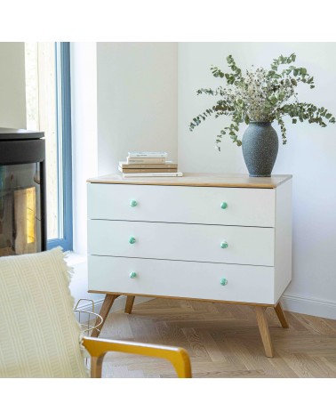 Bouton de meuble en bois de hêtre vert riche poignée design installée sur une commode blanche surmontée d'une plante en pot