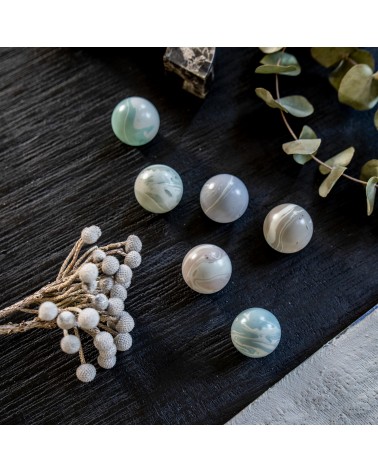 Bouton de meuble en bois de hêtre gris bleu poignée design présenté sur une surface texturée
