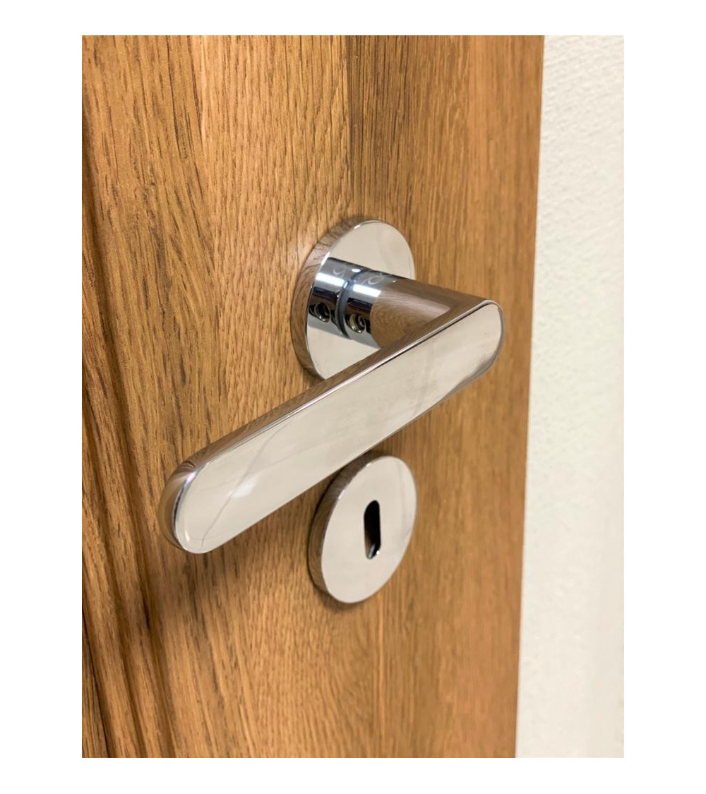 rounded satin chrome door handle at the end of the lever on a wooden door