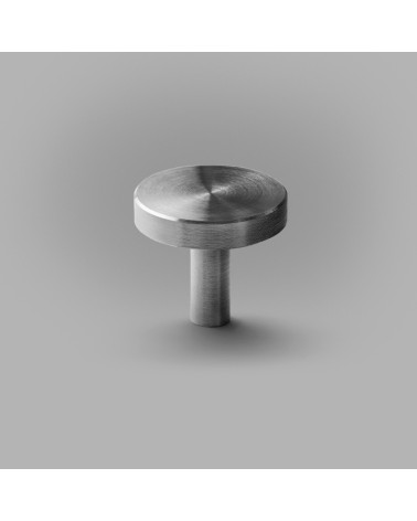 Bouton de meuble chrome poli NENA M poignée design posée sur une surface grise