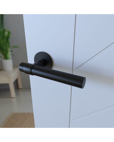 Poignée de porte noire GHOST poignée design montée sur une porte entrouverte