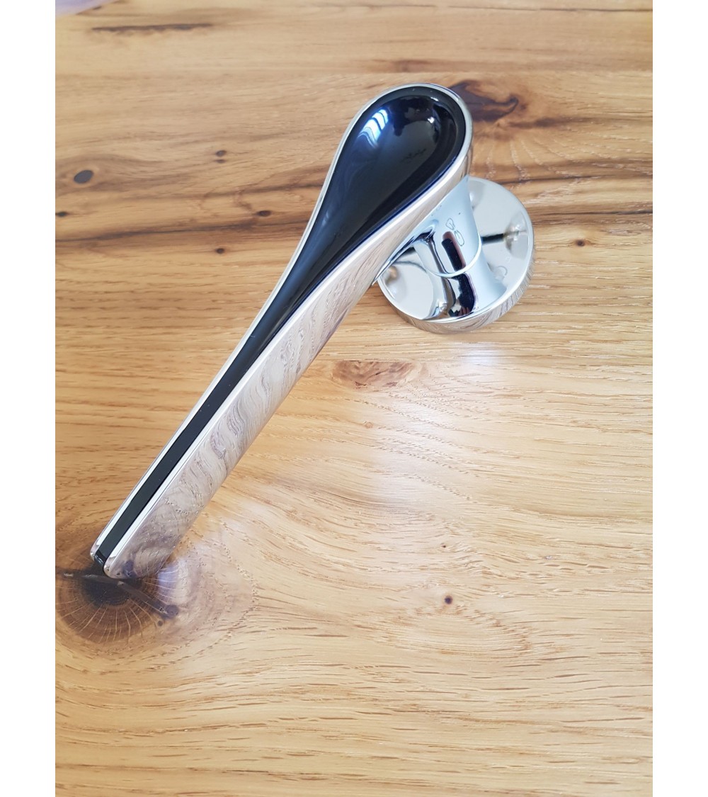 two-tone polished chrome and black door handle on a wooden table