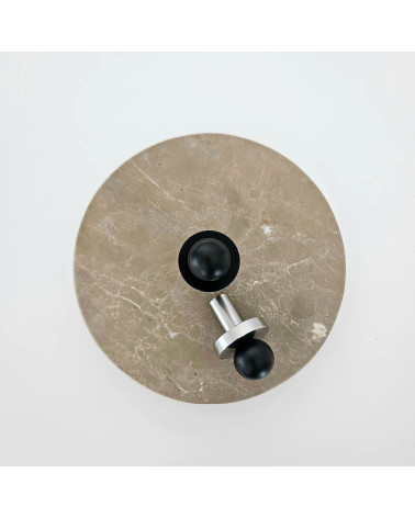 Bouton de meuble noire/chrome poli POLA poignée design vue de haut posée sur une plaque ronde en marbre