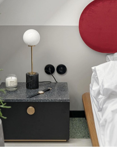 Bouton de meuble or mat TOVE poignée design vue de face installée sur une table à chevet dans une chambre