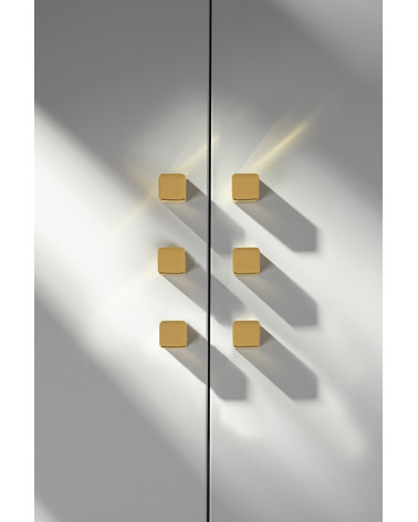 Bouton de meuble en laiton LANA S poignée design vue de face fixée sur une porte grise