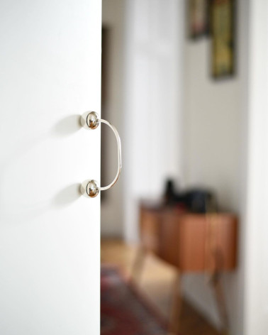 Poignée de meuble en laiton 10 poignée design fixée sur une porte avec un arrière-plan flou