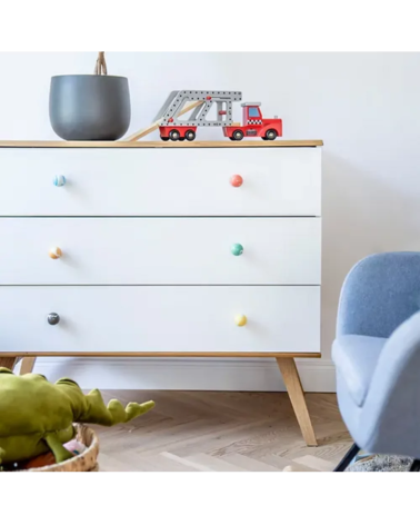 Bouton de meuble en bois de hêtre vert riche poignée design monté sur une commode blanche près d'un fauteuil