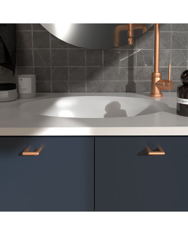 Poignée de meuble cuivre NOX poignée design montée sur un meuble de salle de bain