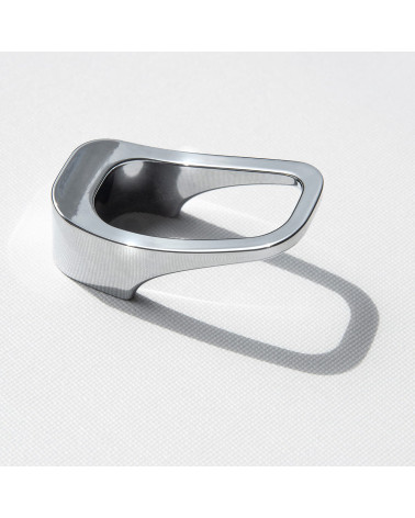 Bouton de meuble chrome poli LAGO poigné design posé sur une surface blanche
