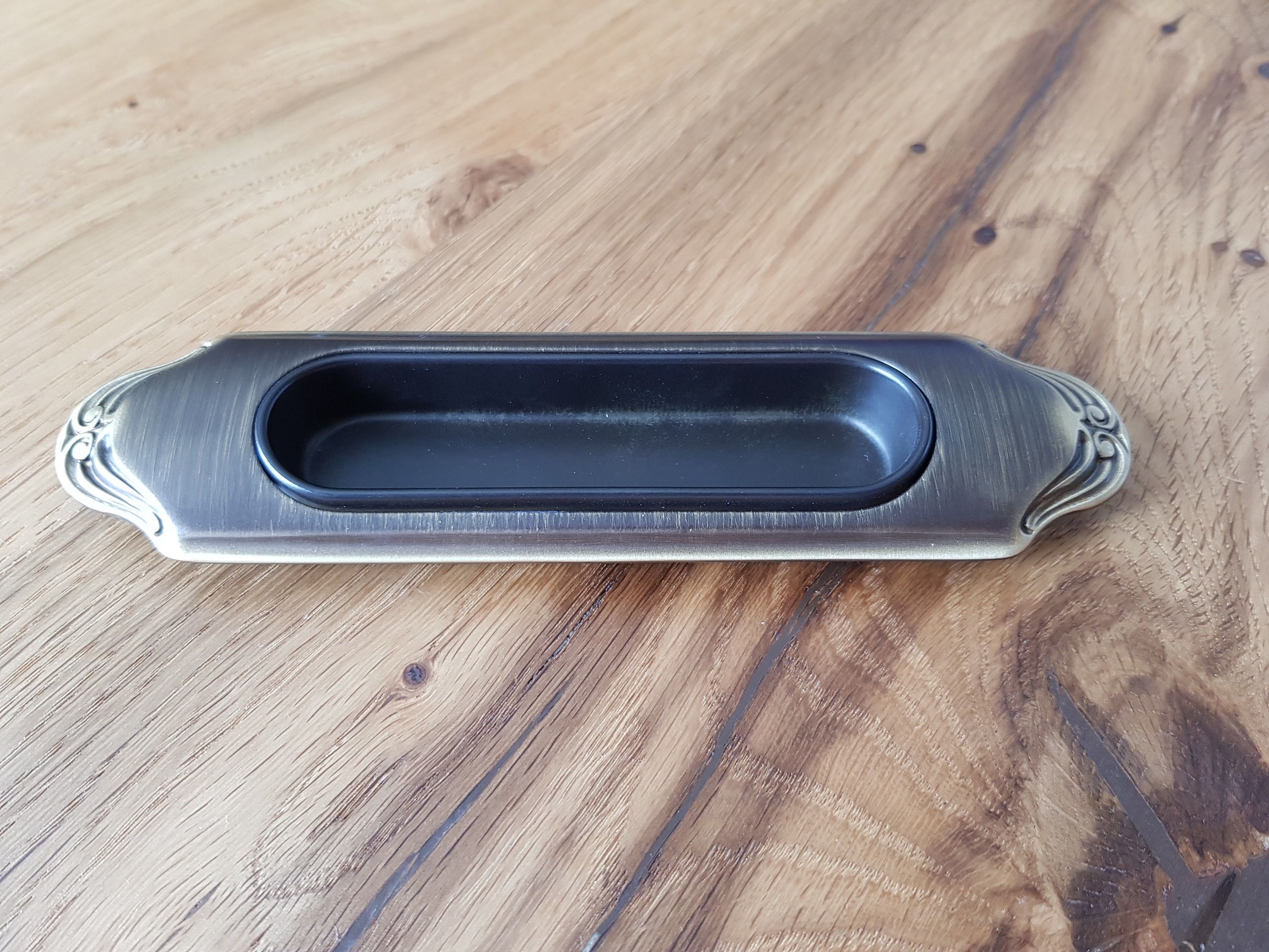 Original recessed handle in a bronze finish to be fitted on a raw wood door