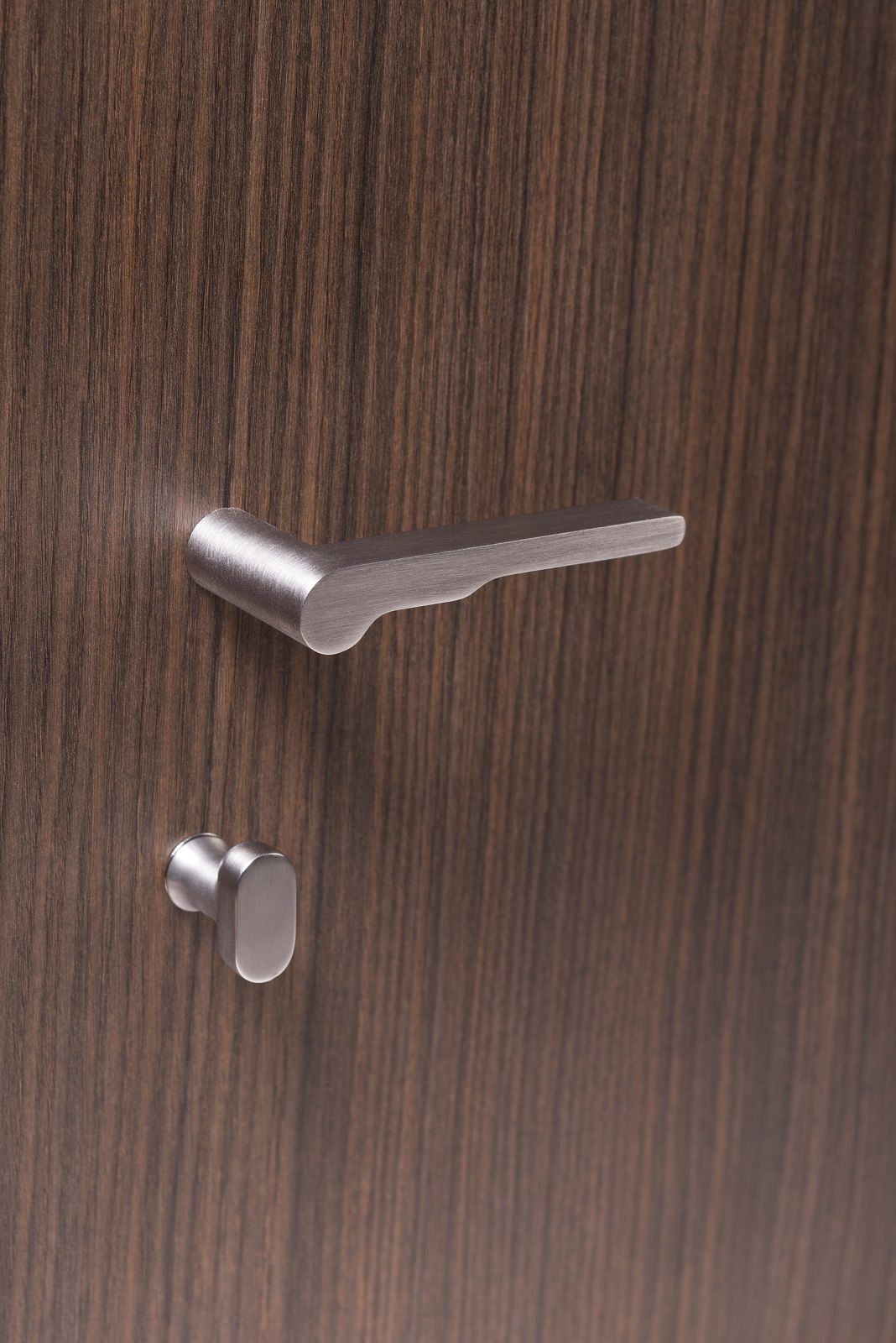 Plateless chrome handle – a clean and modern design on a dark wood-effect door