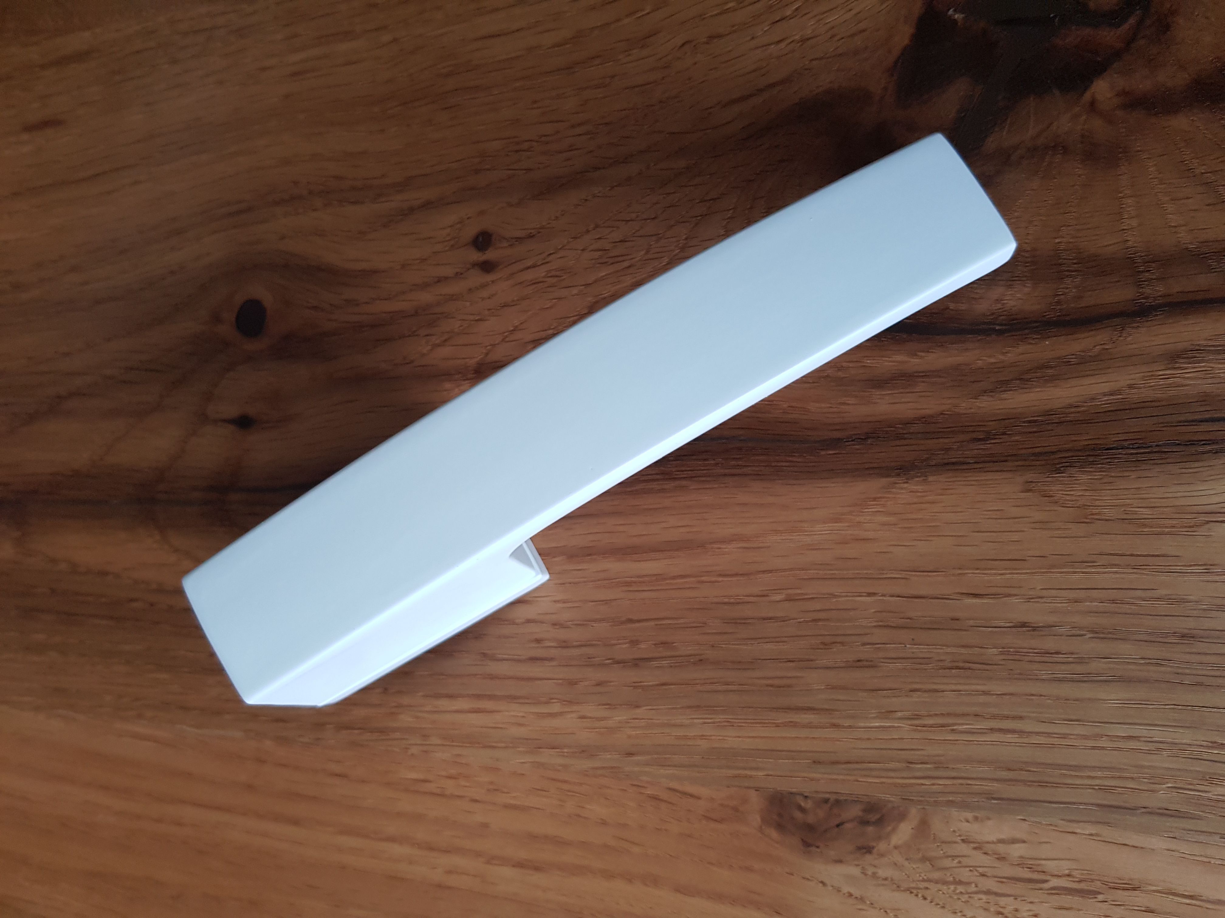White designer door handle on a dark door from Milla Poignées